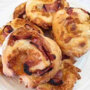 A pile of ham and cheese pinwheels on a plate.