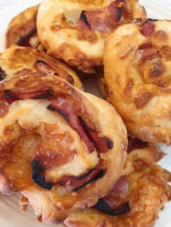 A pile of ham and cheese pinwheels on a plate.