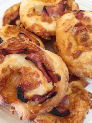 A pile of ham and cheese pinwheels on a plate.