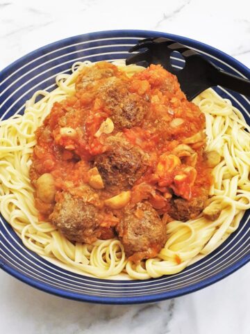 Spicy meatballs in homemade tomato sauce on a bed of spaghetti.