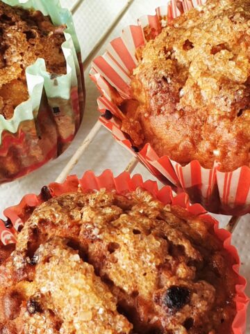 3 apple and oat muffins on a cooling rack.