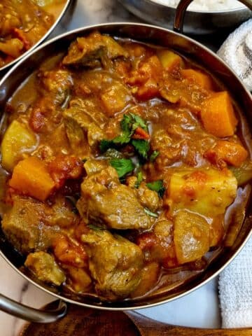 Overhead shot of lamb curry in a balti dish.