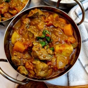 Overhead shot of lamb curry in a balti dish.