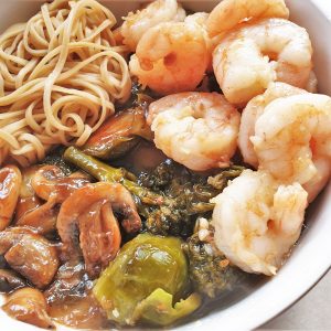 Closeup of a bowl of honey shrimp and steamed vegetables.