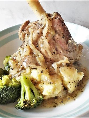 Lamb shank on a plate of mustard mash