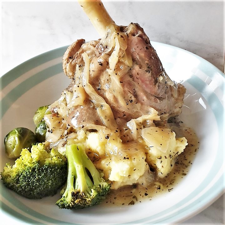 Lamb shank on a plate of mustard mash