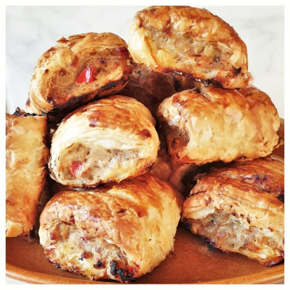 A pile of pork and apple sausage rolls on a plate.