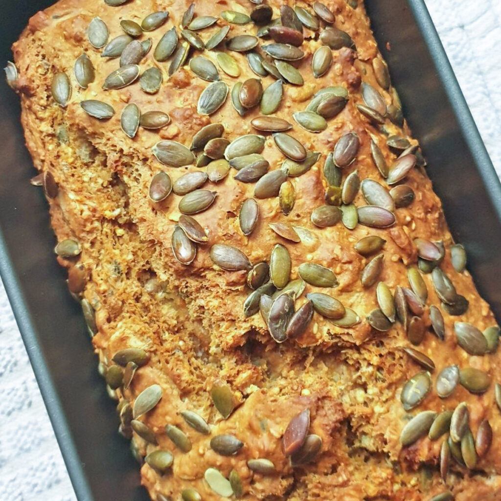 A baked load of seeded Irish soda bread still in the baking pan.