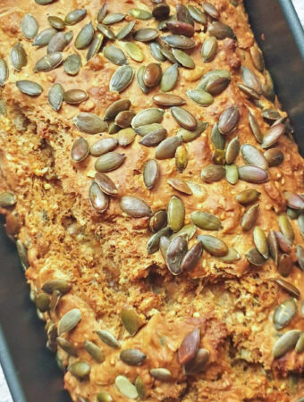 A baked load of seeded Irish soda bread still in the baking pan.