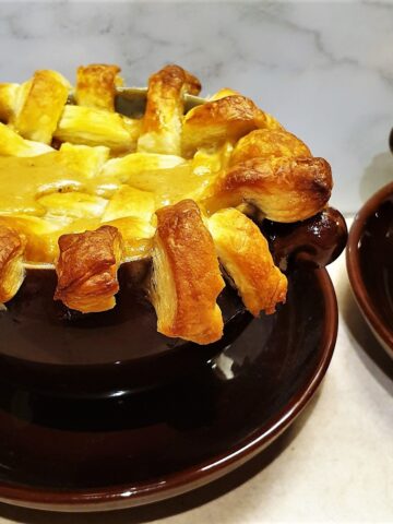 A beef pot pie topped with a lattice of puff pastry.