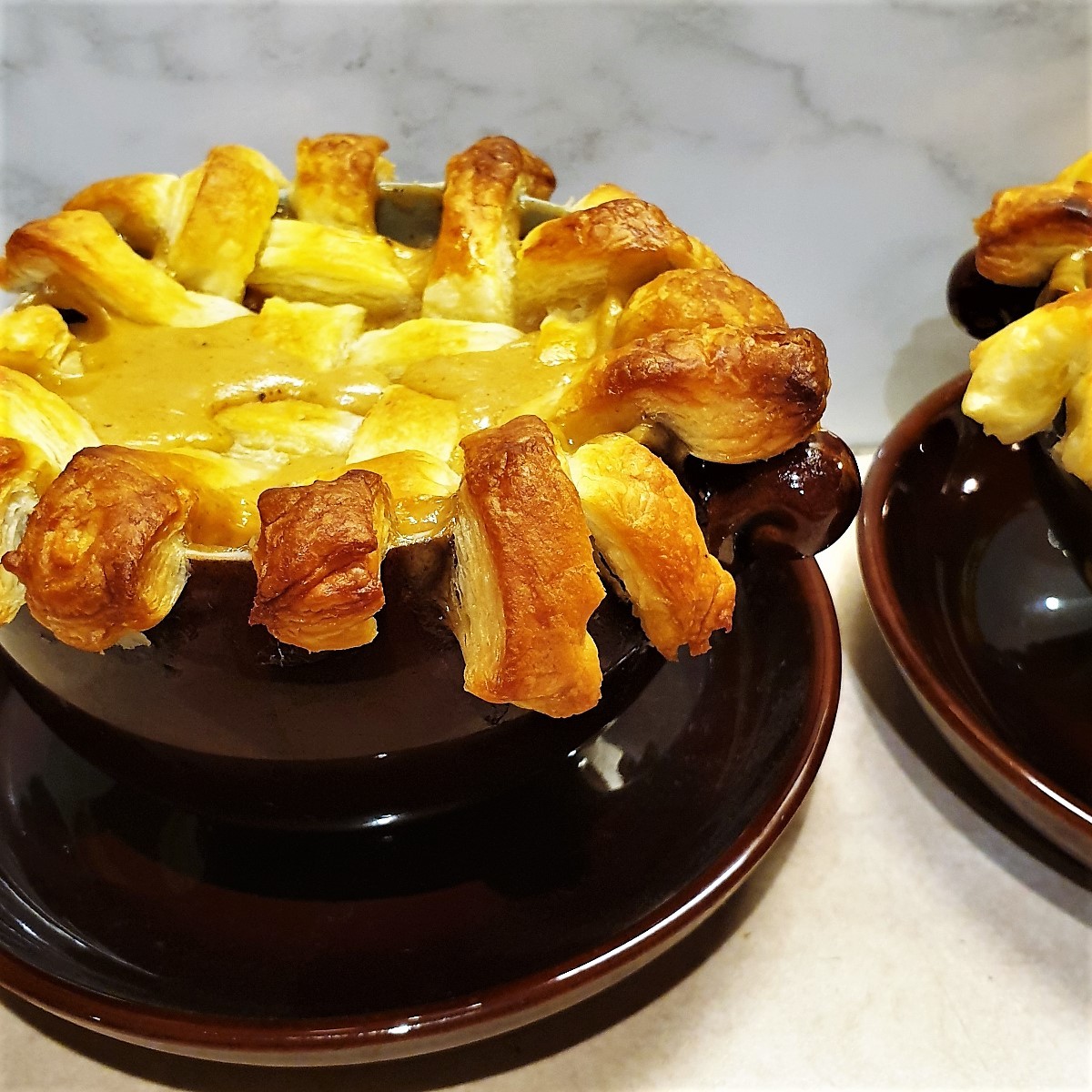 A beef pot pie topped with a lattice of puff pastry.