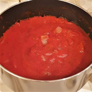 A saucepan of tomato and onion sauce.