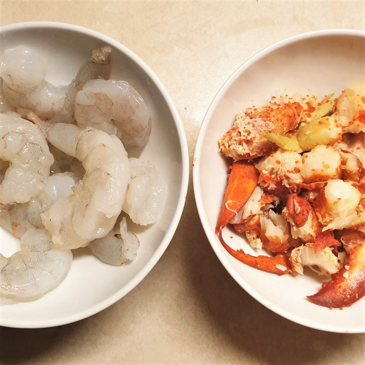 A bowl of shrimp and a bowl of lobster.