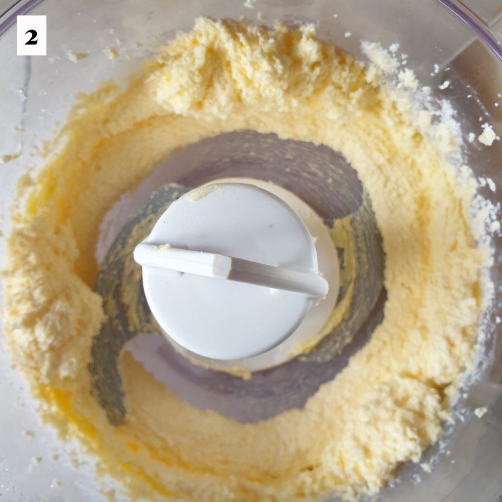 Eggs and sugar being creamed in a food processor.
