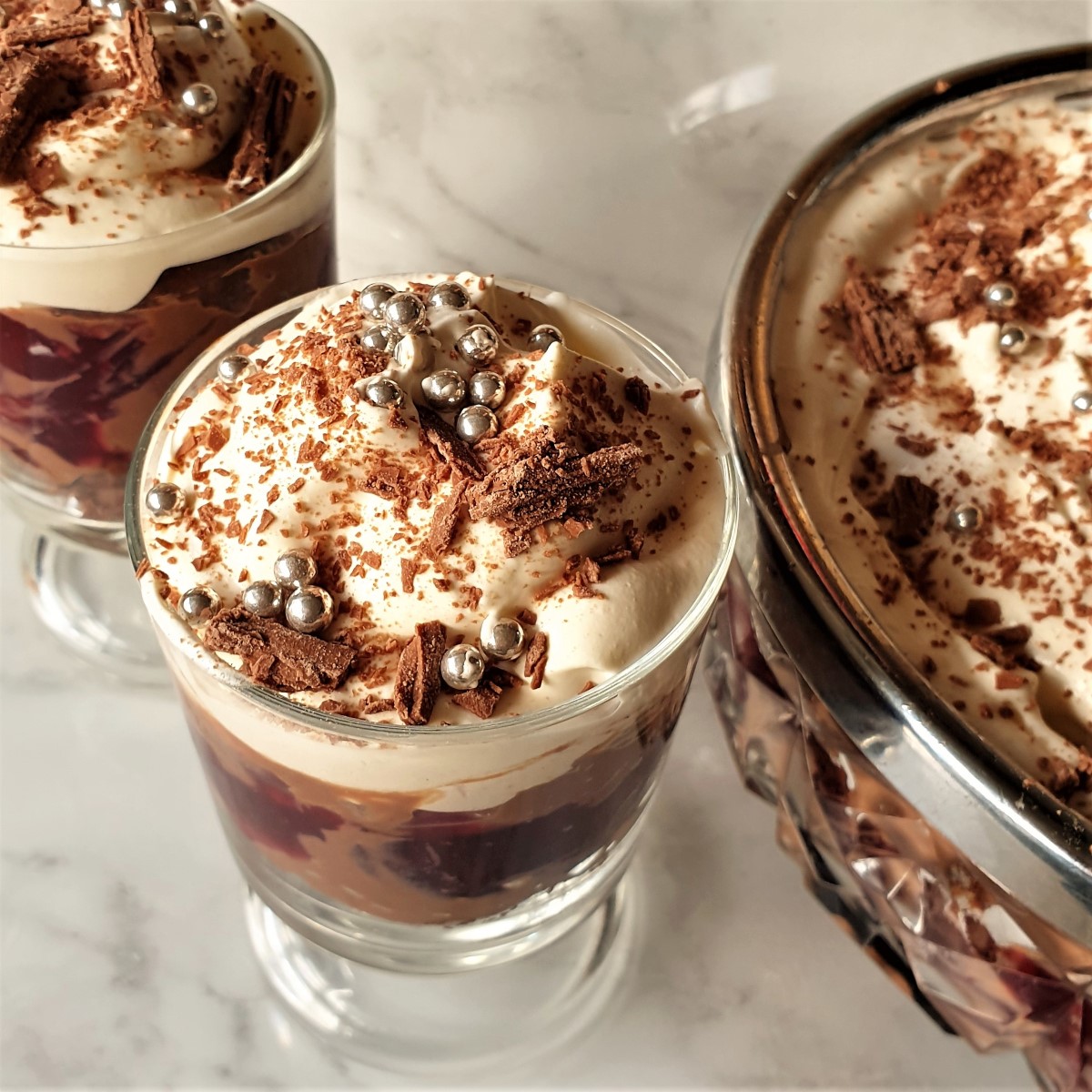 Overhead shot to an individual boozy black forest trile made in a wine glass.