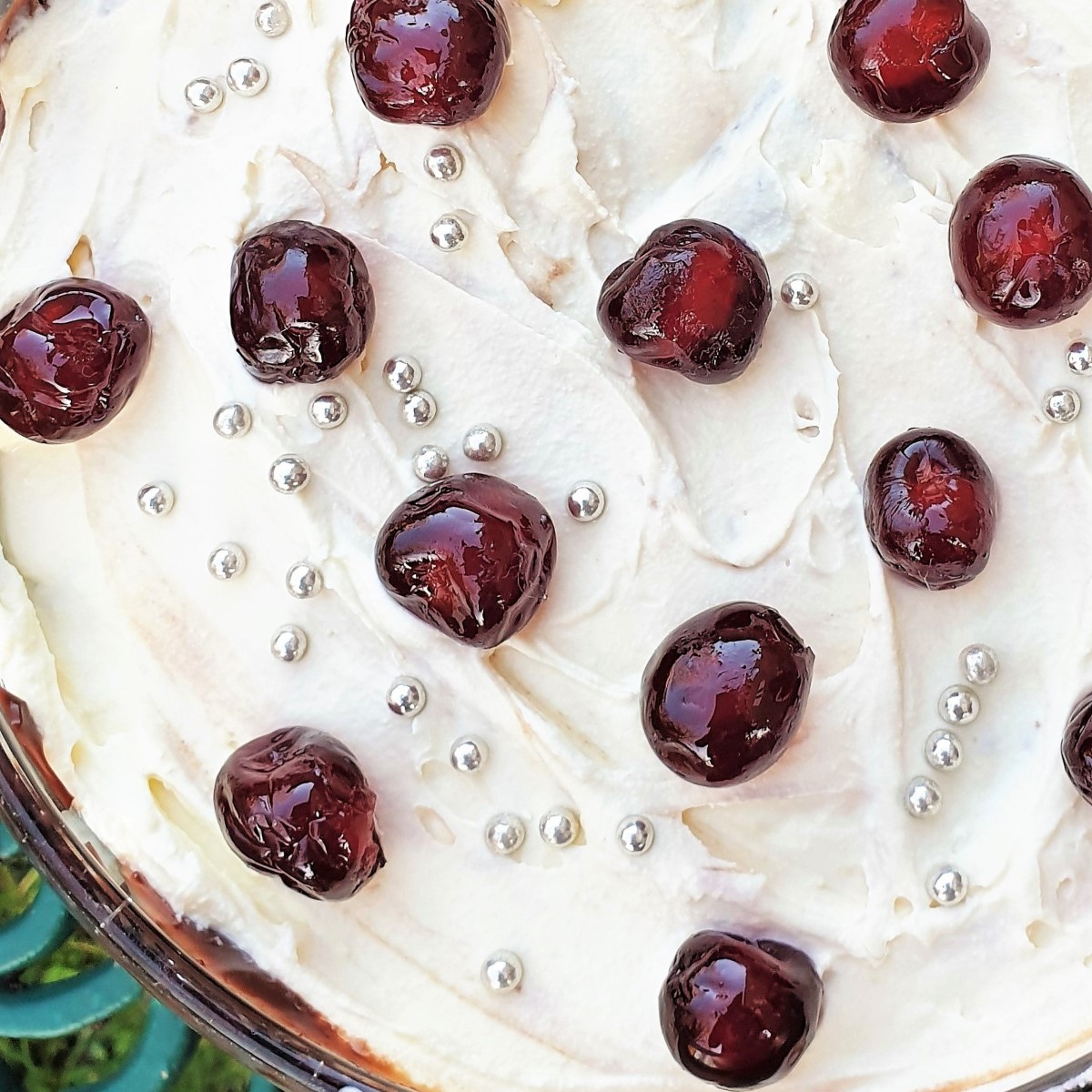 Boozy black forest trifle covered in cream and cherries.