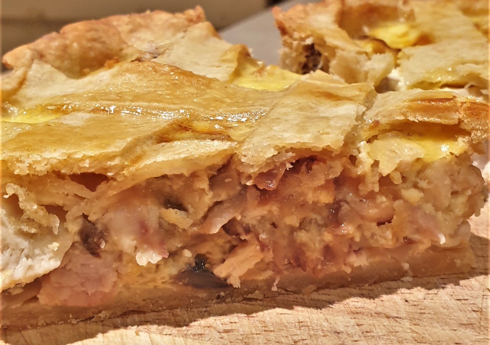 A slice of chicken and mushroom quiche.