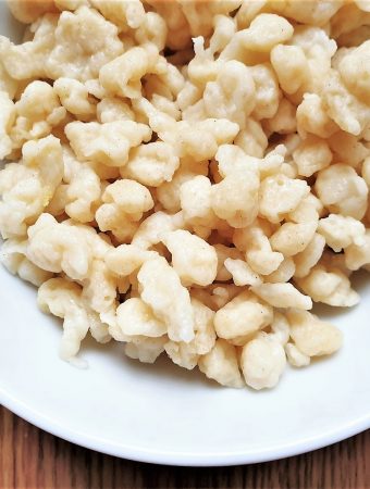 Close up of homemade spaetlze in a white dish.