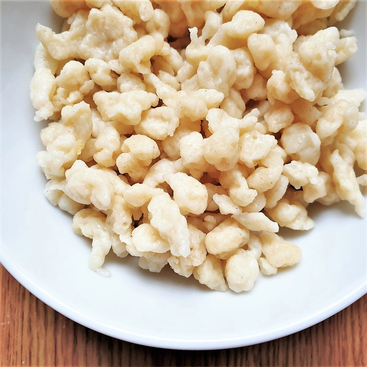 Close up of homemade spaetlze in a white dish.