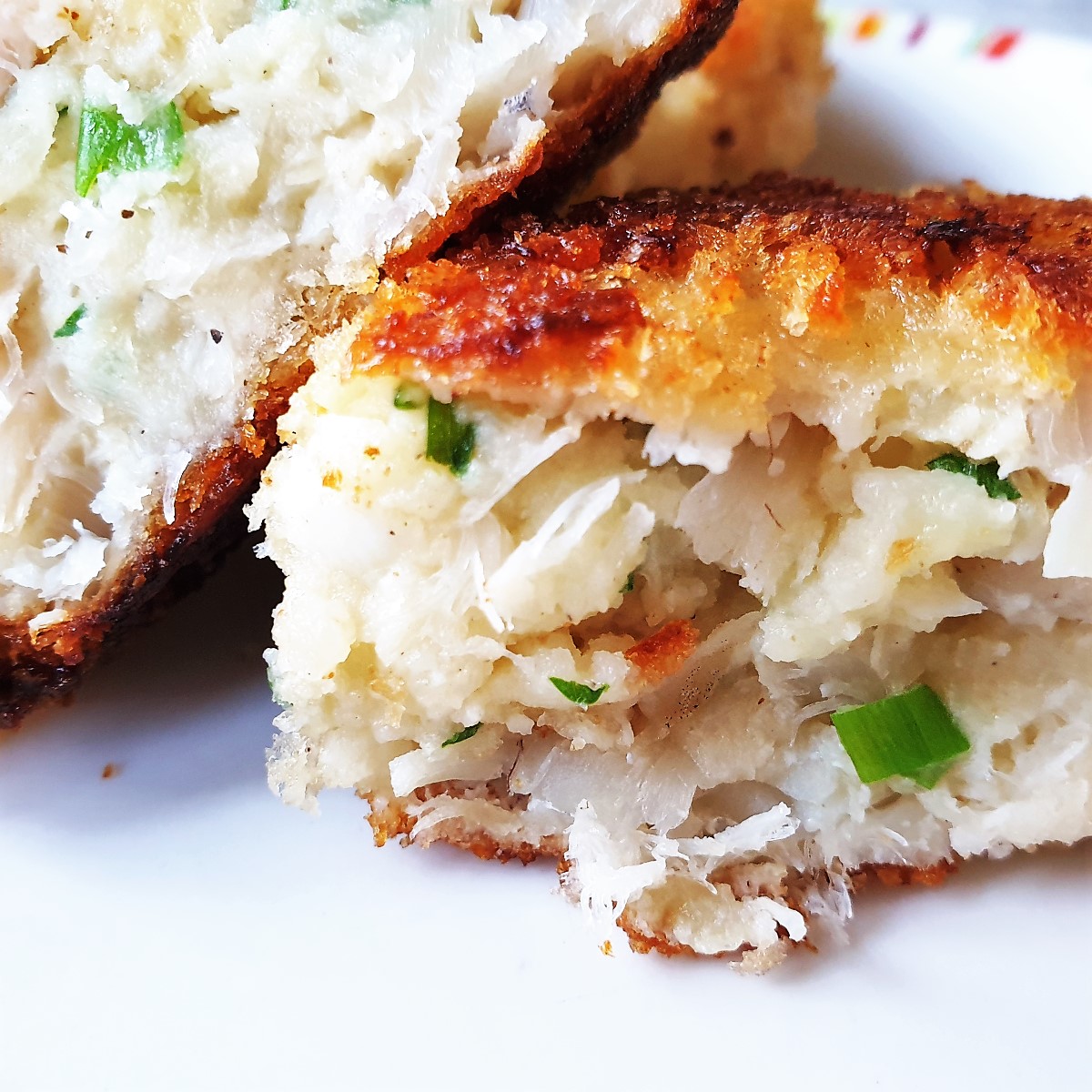 A homemade fishcake cut in half to show the inside. A homemade fishcake cut in half to show the inside.