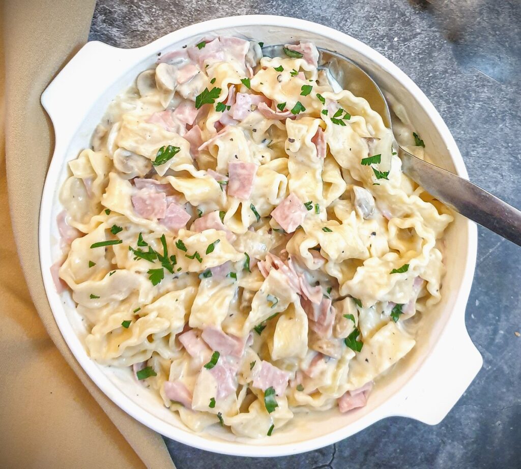 Overhead shot of a dish of ham and mushroom tagliatelle.