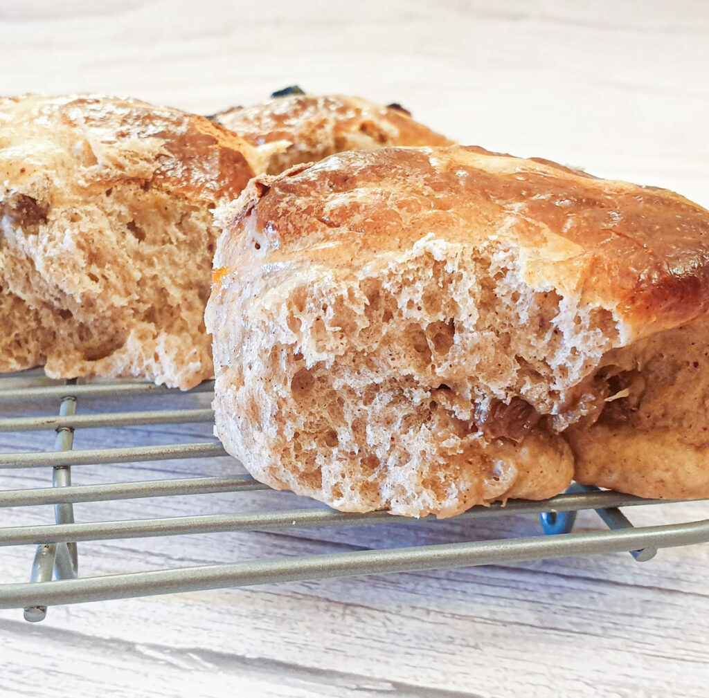 Close up of a hot cross bun showing the fluffy texture.