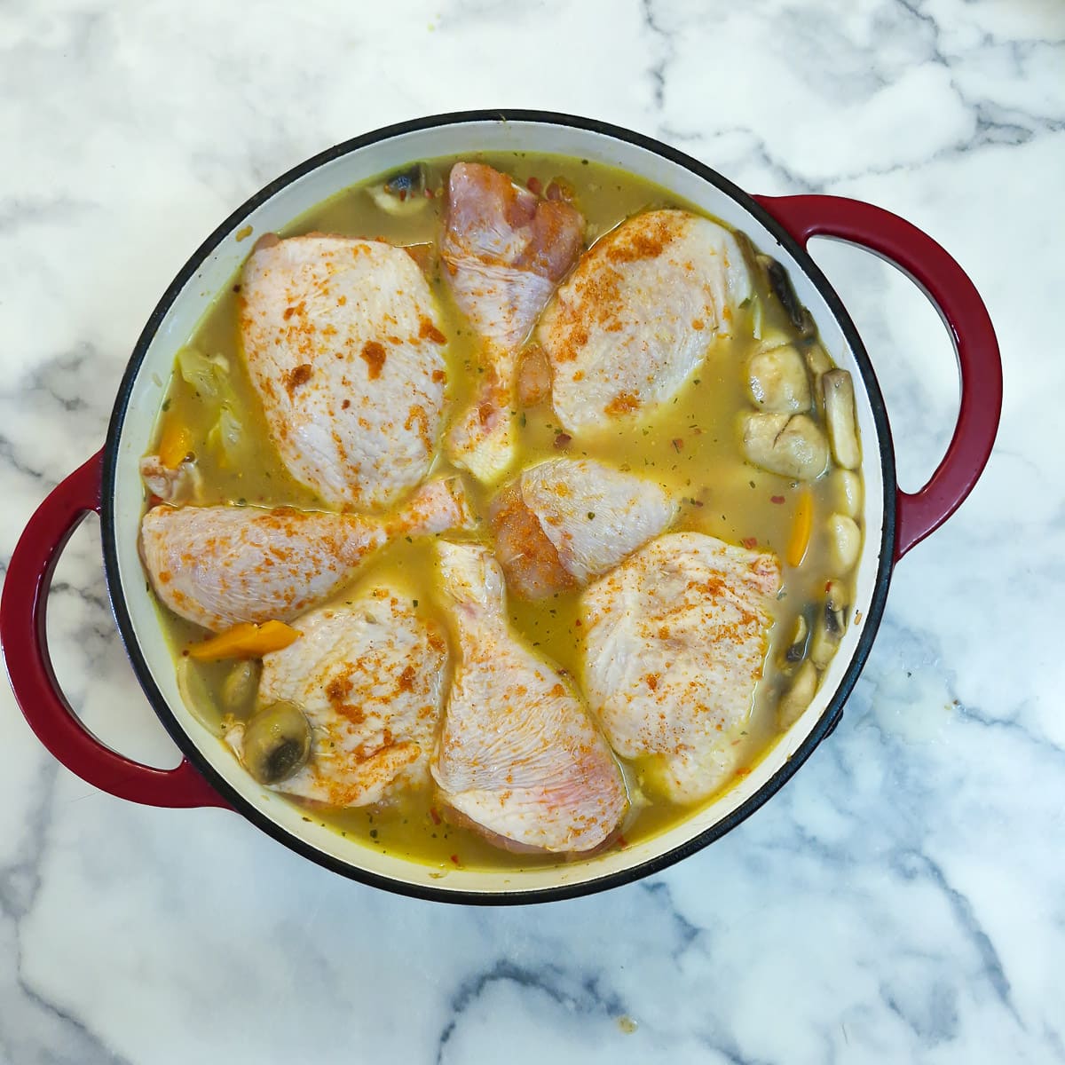 Chicken pieces arranged in the stock.