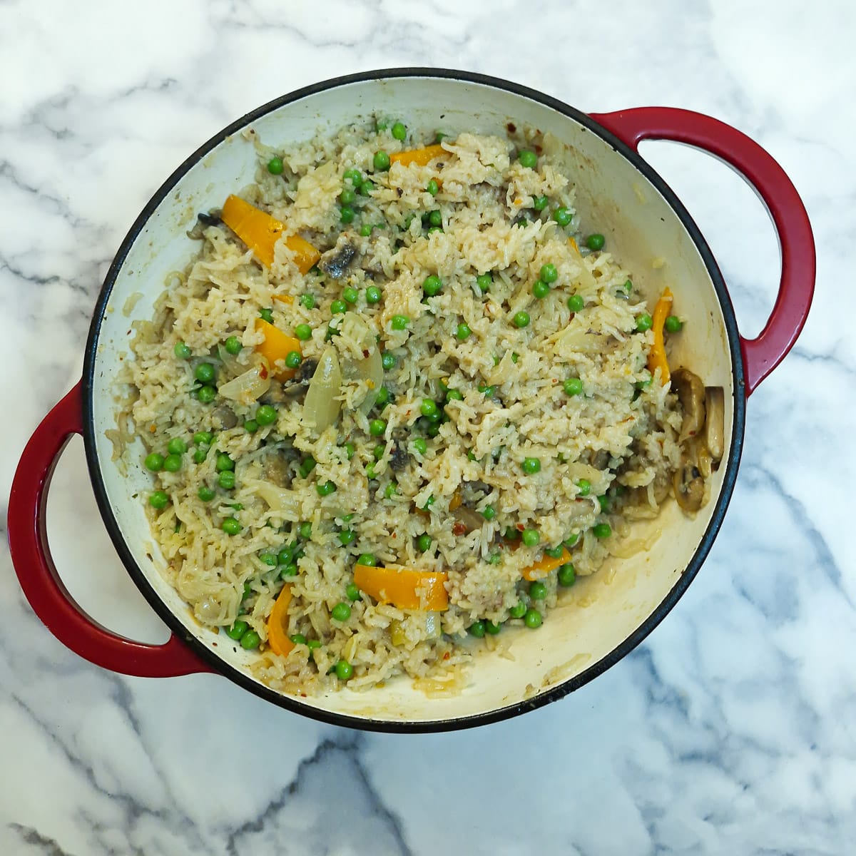 Peas stirred into the rice. The chicken pieces have been removed and will be added back shortly.
