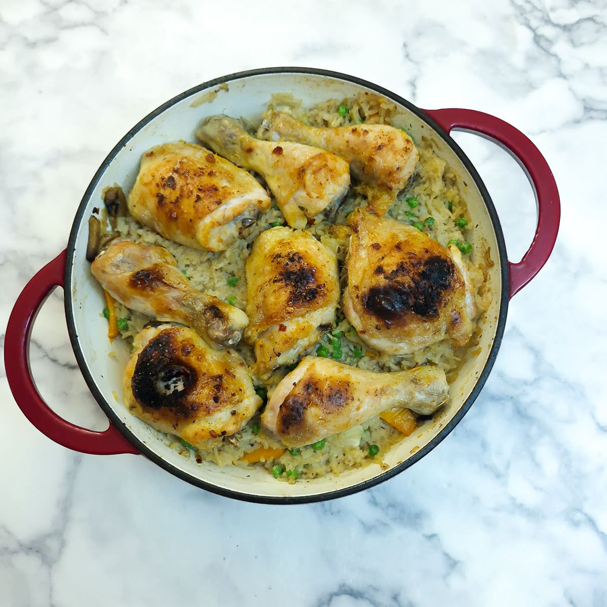 A fully cooked dish of garlic chicken and rice, with browned chicken pieces on top.