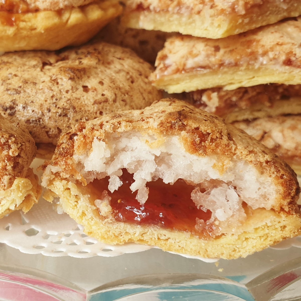 Close up of the inside of a coconut meringue jam tart on a plate.