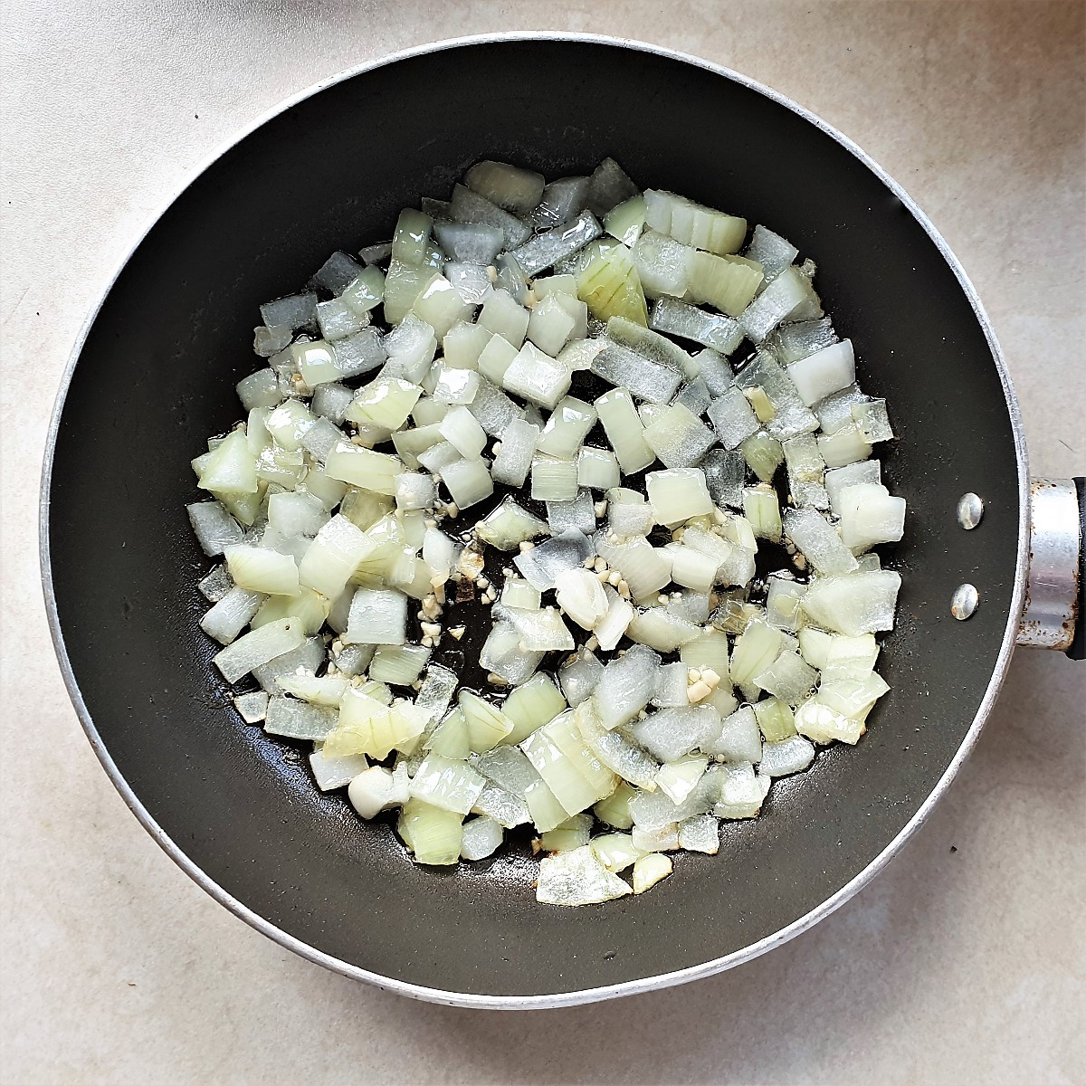 Chopped onions and garlic frying in a pan