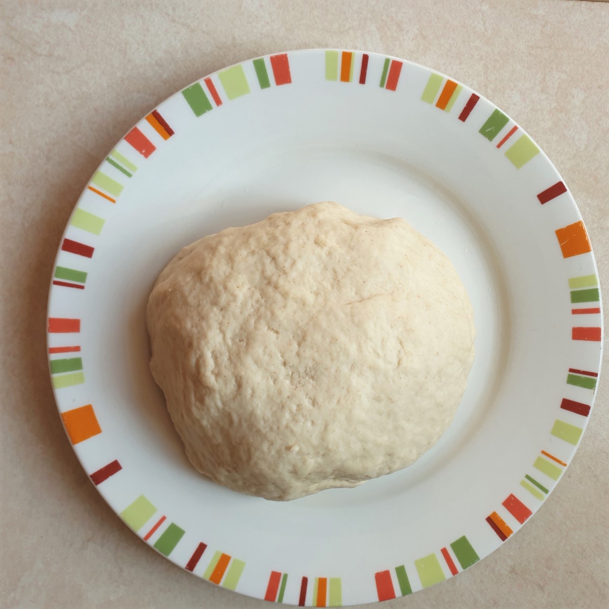 A ball of samosa pastry on a plate, ready for rolling.