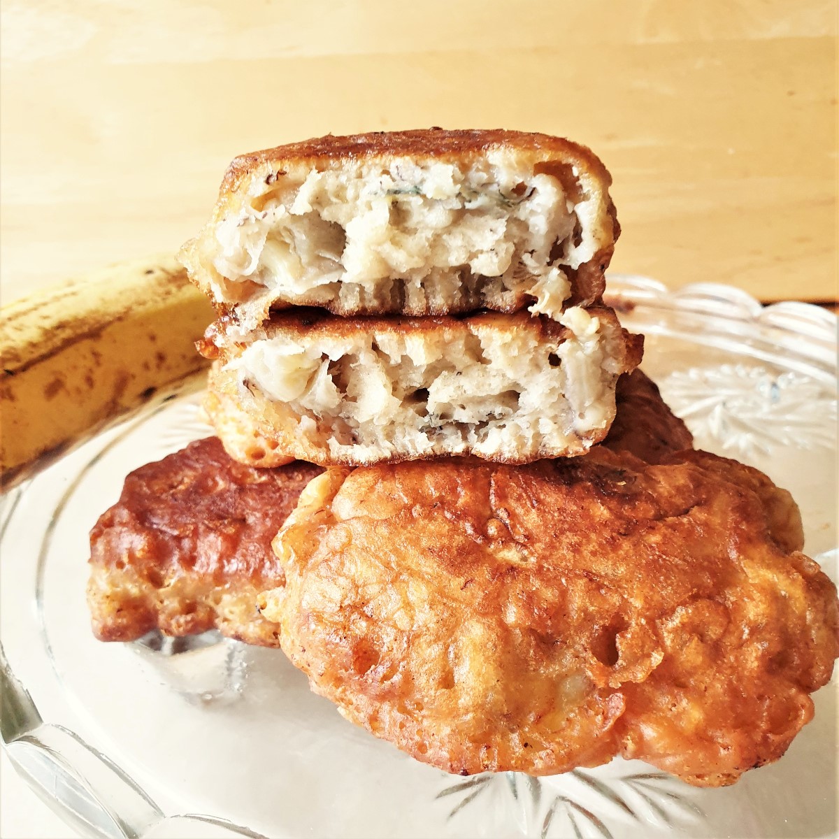 A banana fritter cut in half, showing the inside texture.