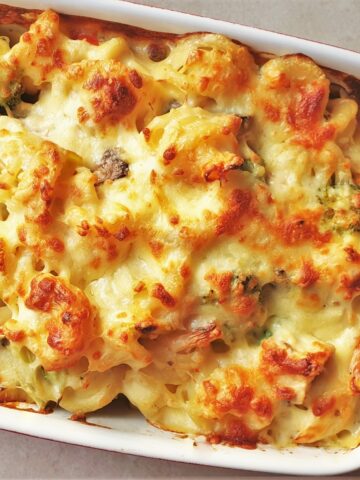 A baked dish of cheesy chicken and vegetable pasta.