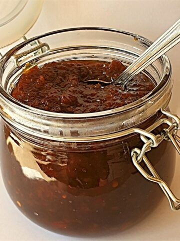 An open jar of Mrs Balls chutney with a spoon.