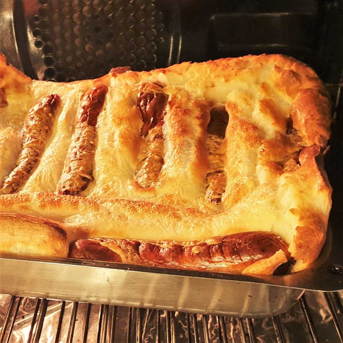 A tray of toad in the hole showing the sausages covered in wll-risen batter