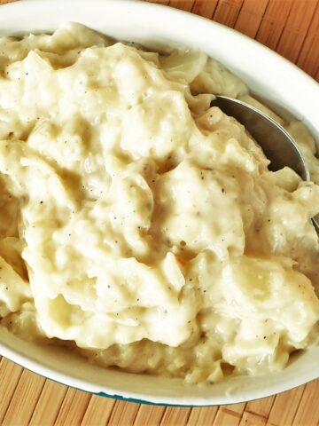 A dish of creamed cabbage with a spoon.