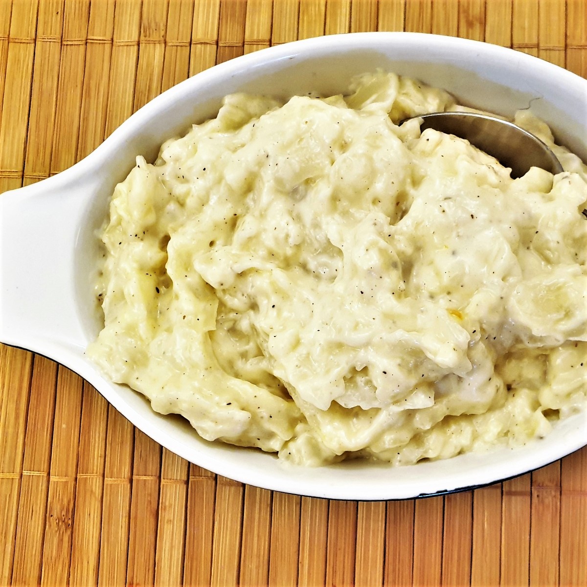 A dish of creamed cabbage with a spoon.