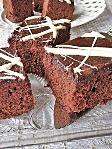 Squares of quick mix chocolate cake on a glass plate.