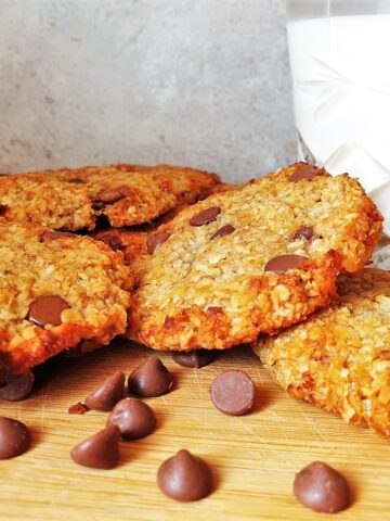 Banana oat cookies next to a glass of milk.