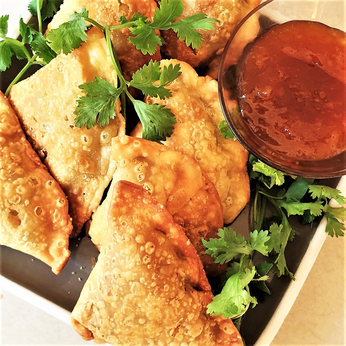 A plate of samosas with beef, pea and potato filling.