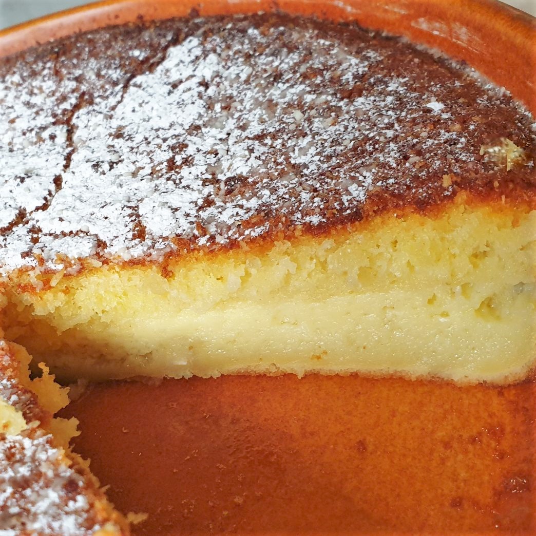 A coconut pie with a slice removed.