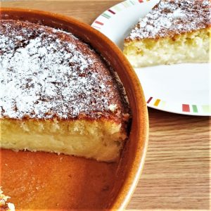 A coconut pie with a slice removed onto a plate.