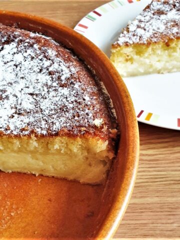 A coconut pie with a slice removed onto a plate.