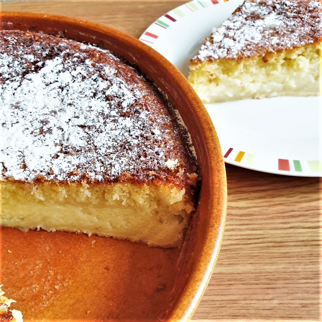 A coconut pie with a slice removed onto a plate.