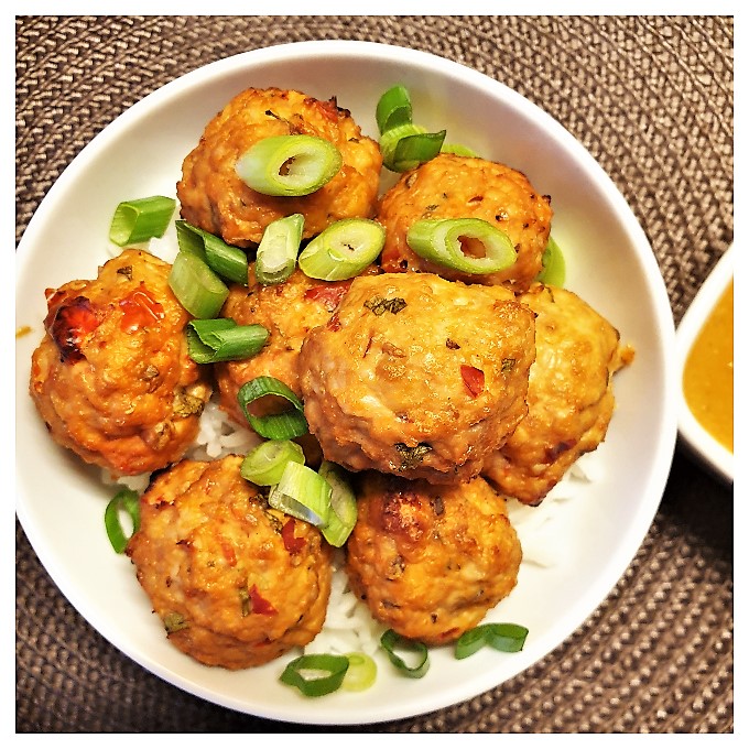 A dish of Thai meatballs sprinkled with chopped spring onions.