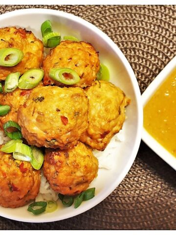 A dish of thai meatballs sprinkled with spring onions