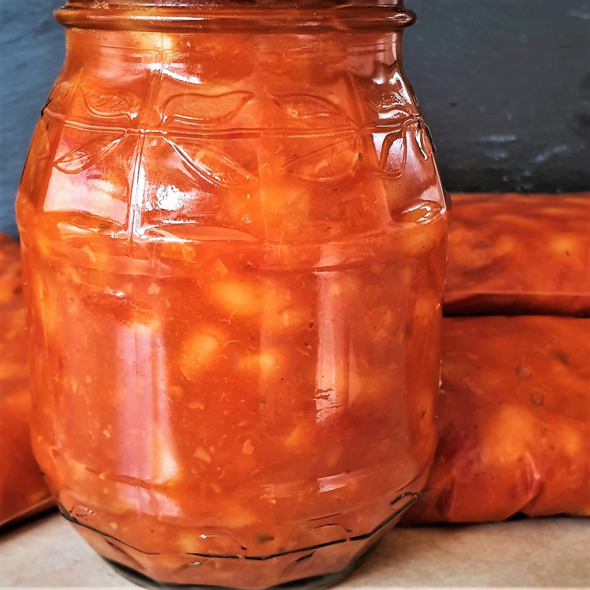 A jar of baked beans alongside some freezer bags of beans.