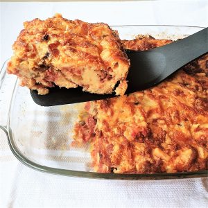 A slice of bully beef quiche being lifted from the dish.