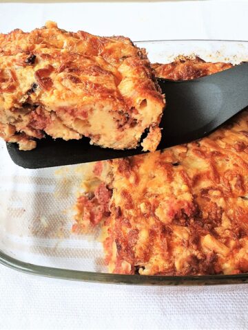 A slice of bully beef quiche being lifted from the dish.